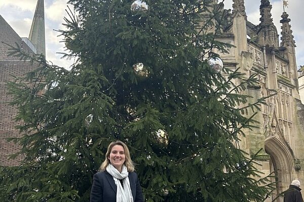 Jess Brown-Fuller infront of the Chichester Christmas Tree at the Cross